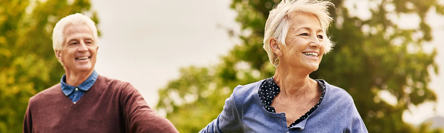 A smiling older couple walking outdoors
